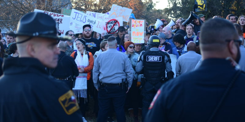 Crowd of protesters facing sheriffs deputies and riot police